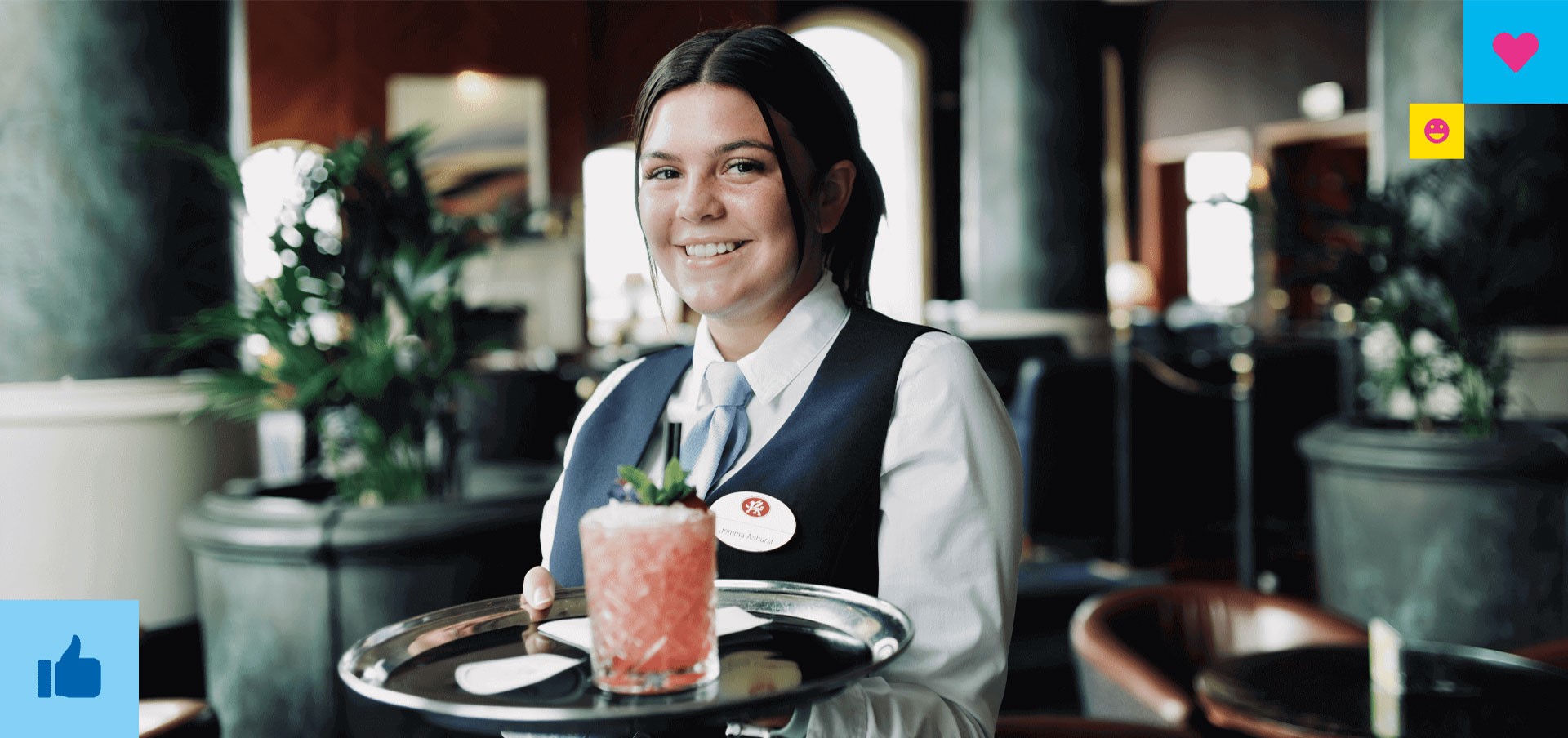 A waitress holding a drink on a tray in a hotel bar