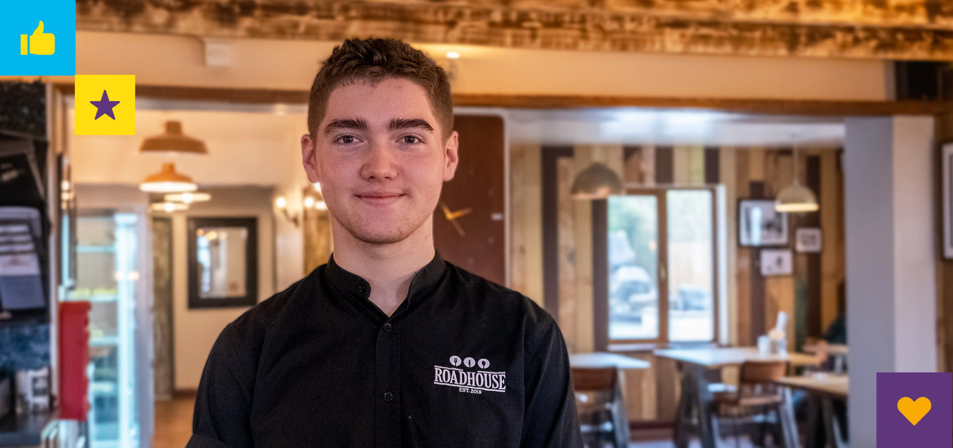 Hospitality trainee, Kieran, standing in the restaurant dining area
